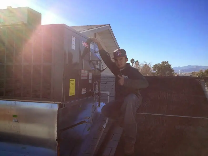 HVAC technician performing Air Duct Cleaning on a rooftop unit in Port Townsend
